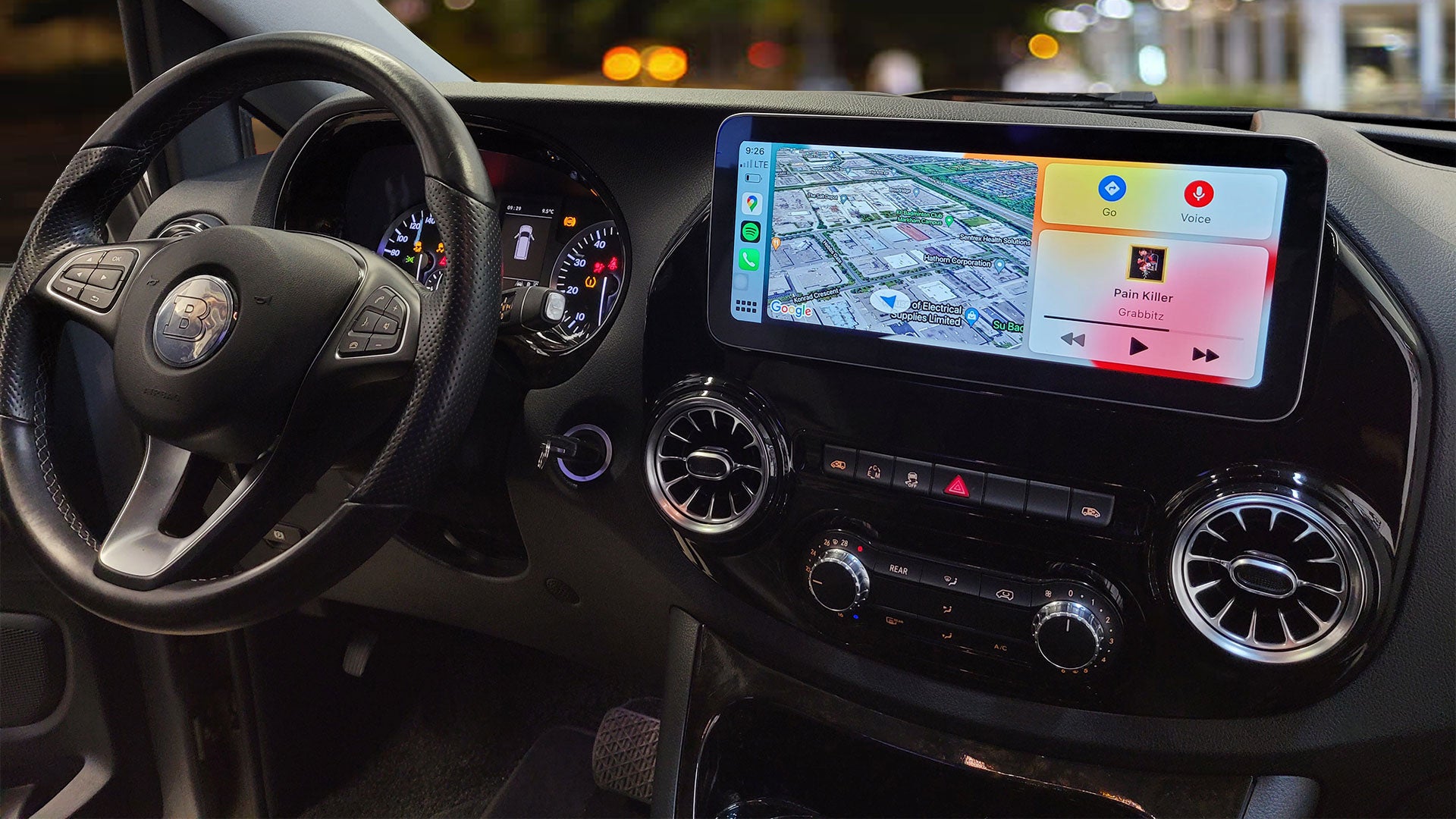 Car interior with a touchscreen display showing navigation and music controls.
